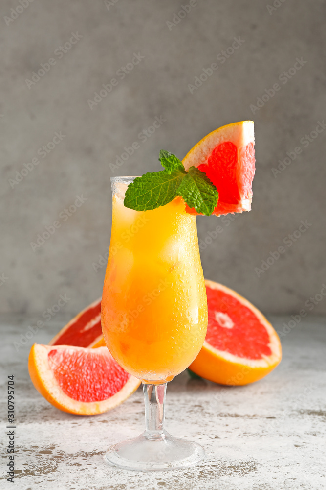 Glass of fresh citrus juice on table