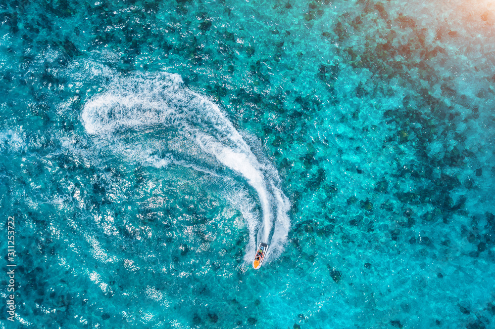 夏季日落时，漂浮在清澈水中的滑板车鸟瞰图。在印度洋度假，Z