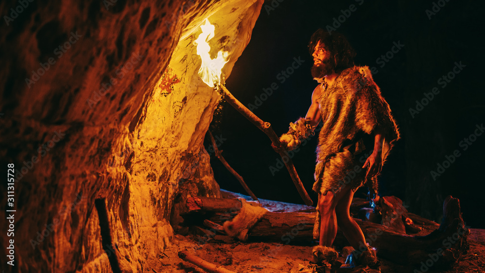 原始洞穴人晚上披着兽皮探索洞穴，手持火把看着德拉伊