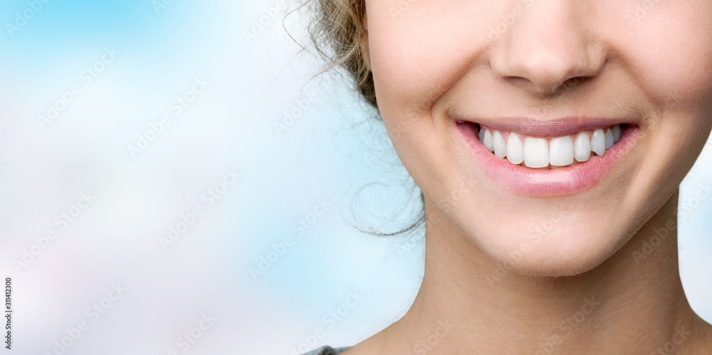 拥有健康洁白牙齿的年轻女性的美丽笑容