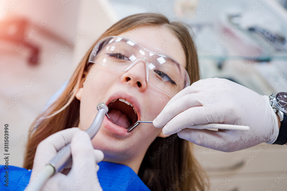 在牙医进行口腔检查时，女性张开嘴巴的特写。口腔医学概念。特写