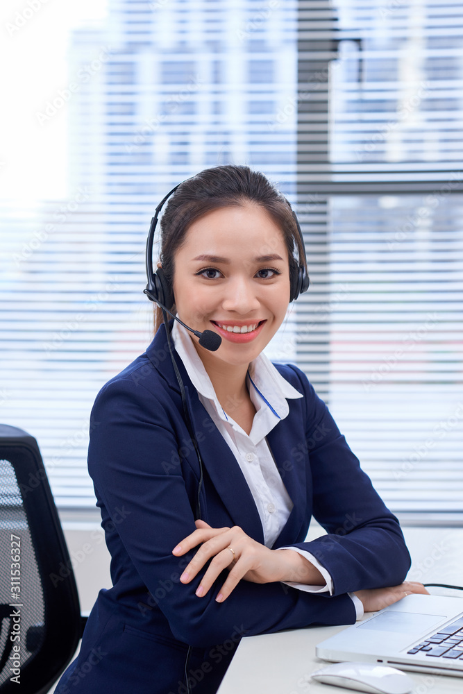 工作场所快乐微笑的女性客户支持电话接线员的画像。亚洲人