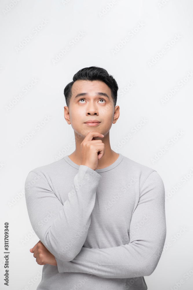 一幅年轻的亚洲男子在白色背景下独自抬头思考的画像