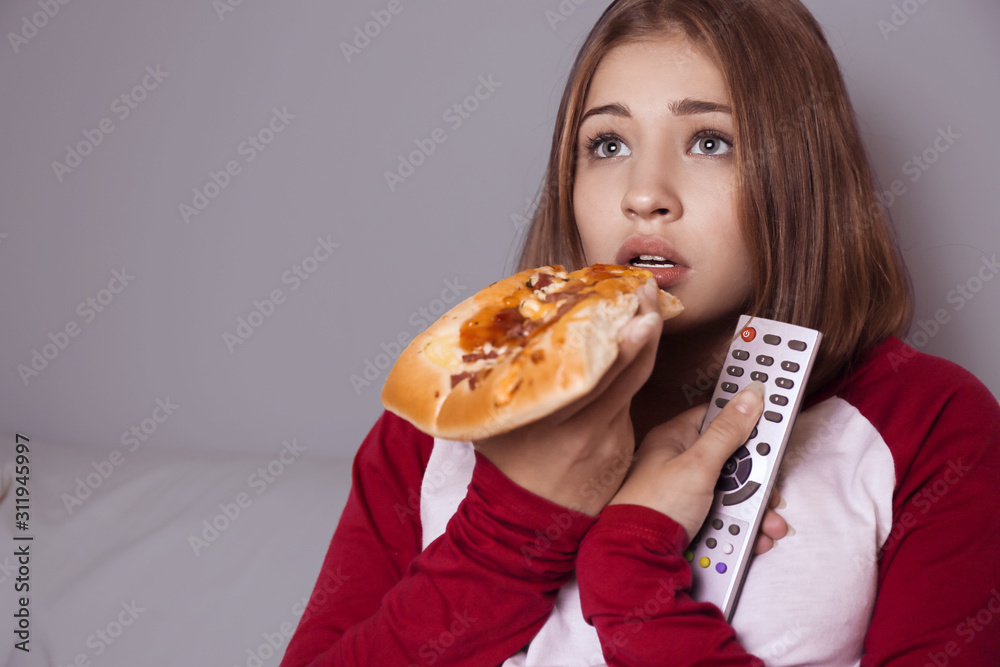 深夜看电视时吃披萨的少女