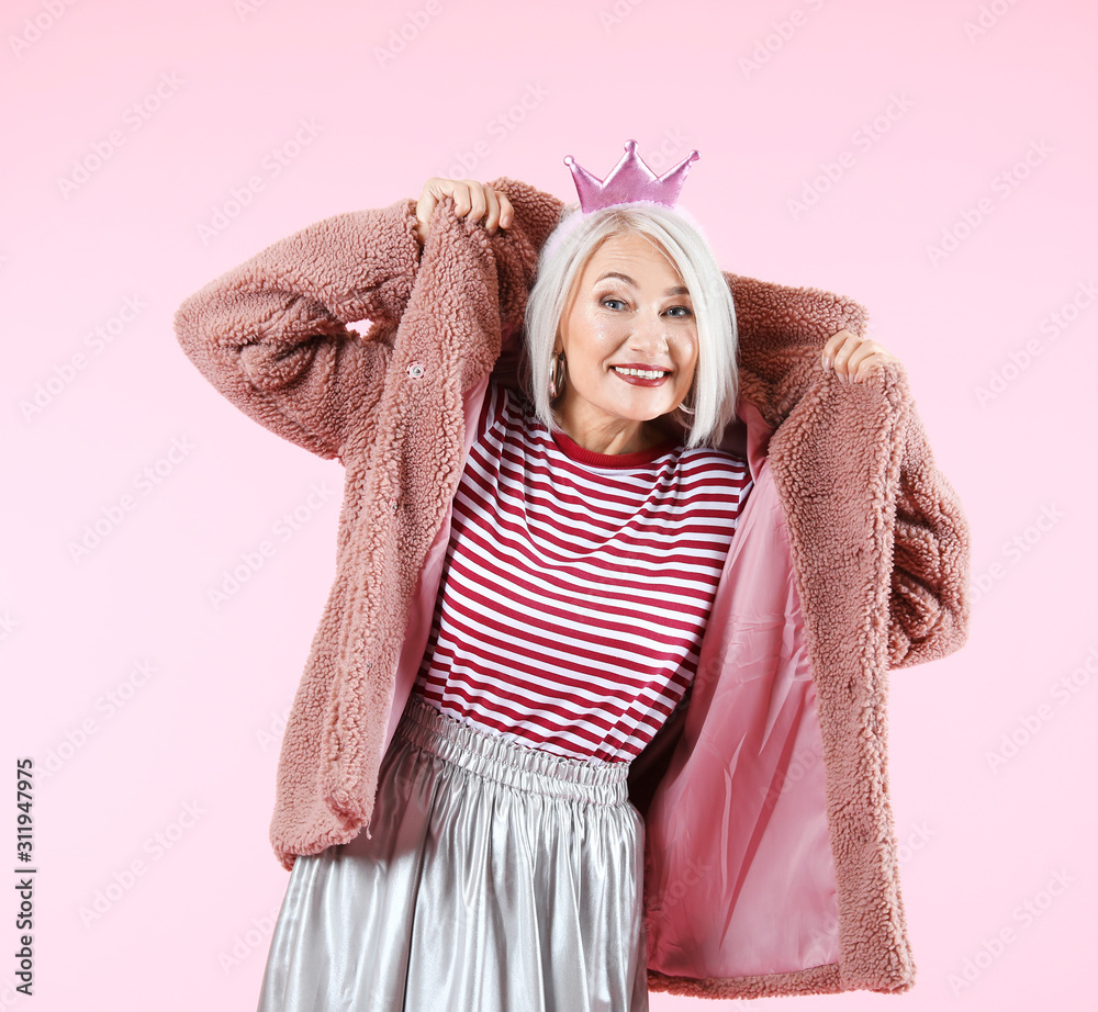 Cool fashionable mature woman on color background