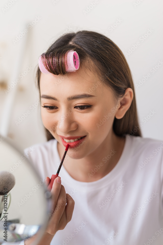 Asian woman beauty blogger,vlogger applying lipstick to her mouth doing cosmetic makeup tutorial