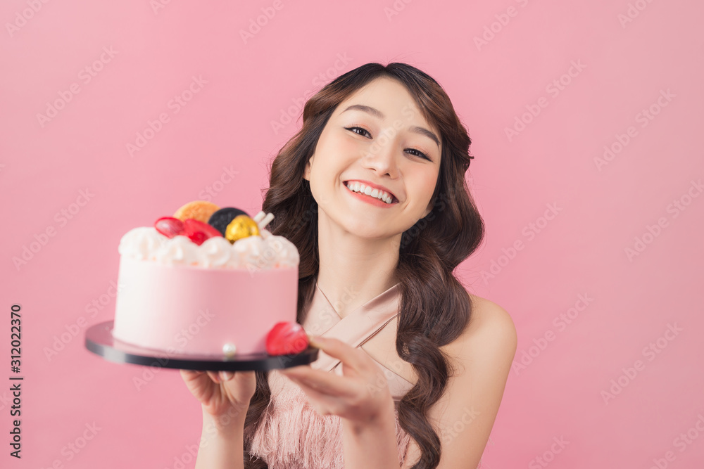 慷慨的女人拿着生日蛋糕正面粉色背景