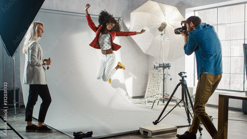 照片拍摄的后台：瞬间摄影师拍摄跳跃美丽黑人模特智慧的照片