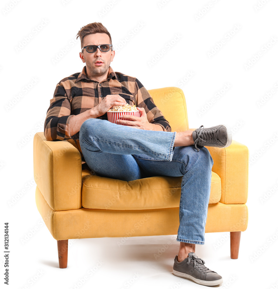 情绪激动的男人坐在白底扶手椅上看电影