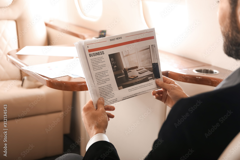 商人在现代私人飞机上读报