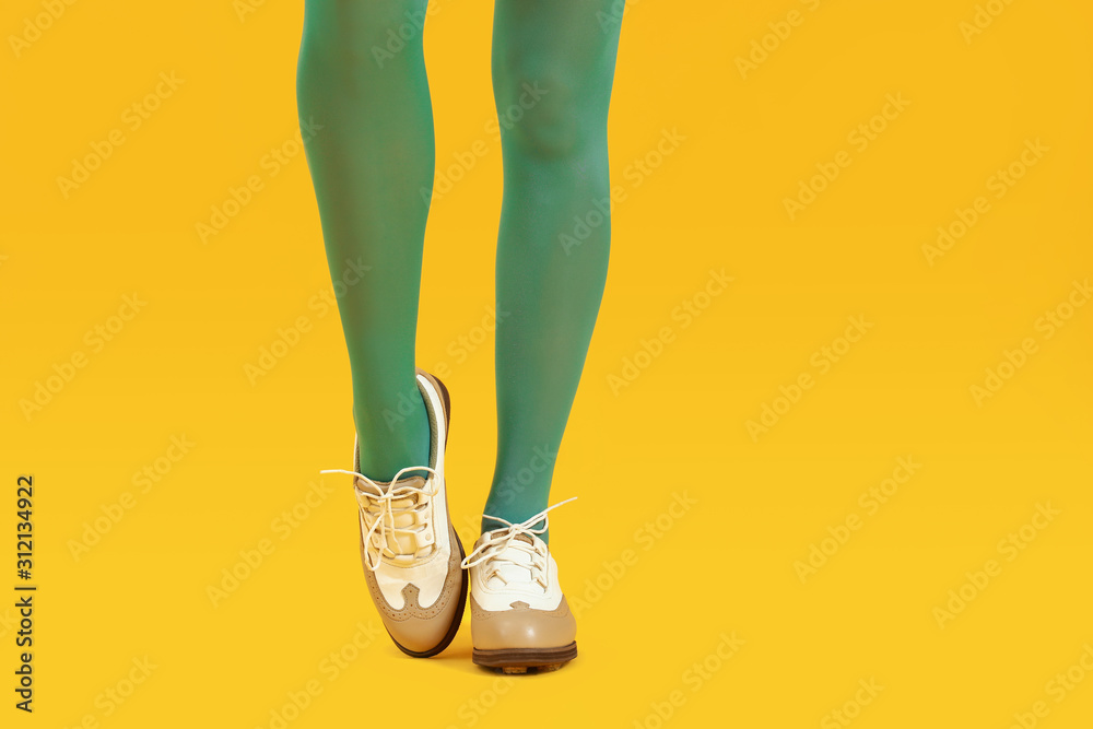 穿着时尚鞋和紧身裤的彩色背景年轻女性的腿