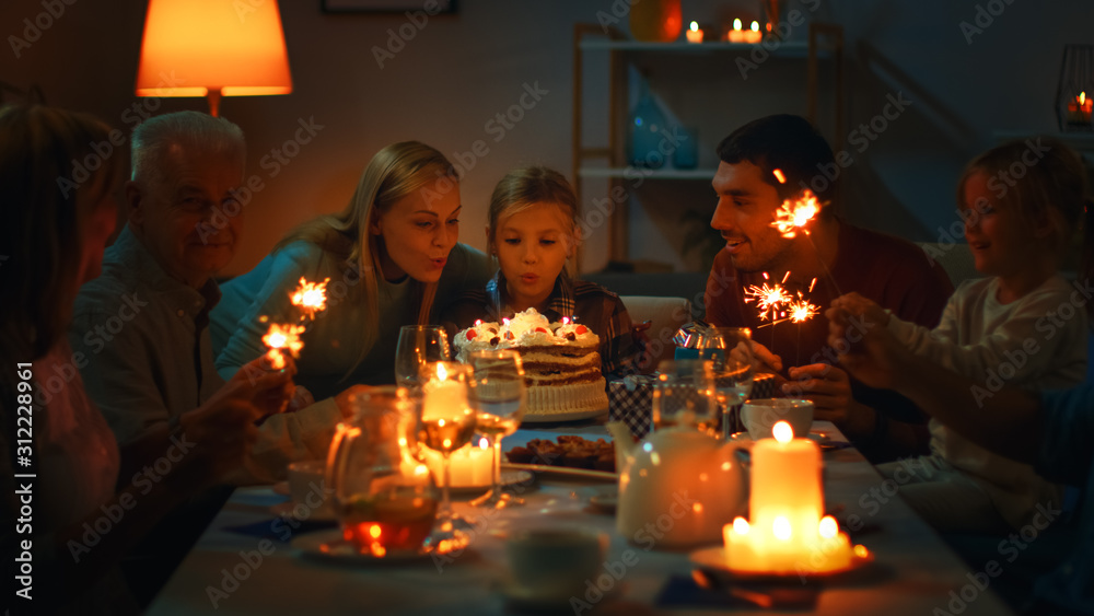 餐桌上可爱小女孩的生日庆祝活动，带妈妈的女孩吹蜡烛。在