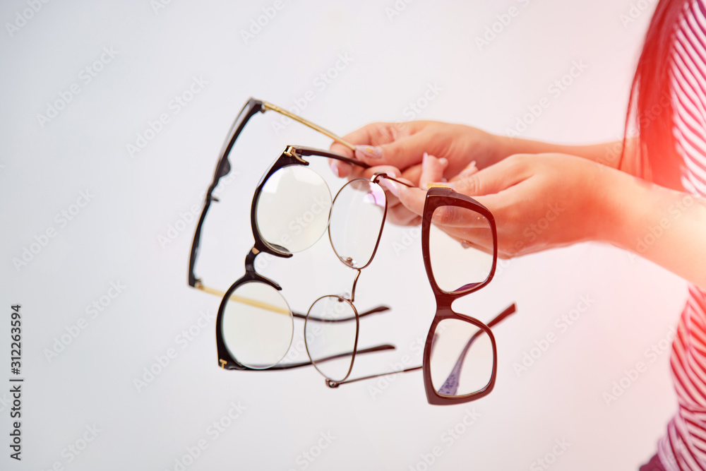 女孩手中的四副白色隔离眼镜。眼镜展示。特写
