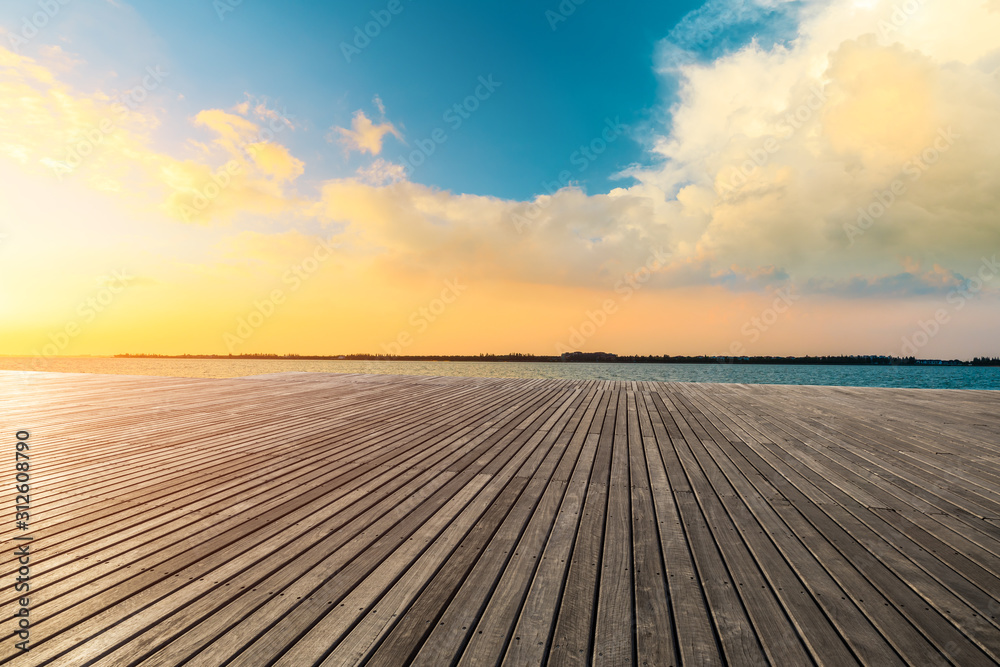 日落时的湖畔木地板平台和天空云朵。