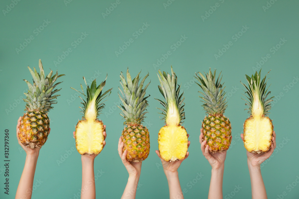 彩色背景上有多汁菠萝的手