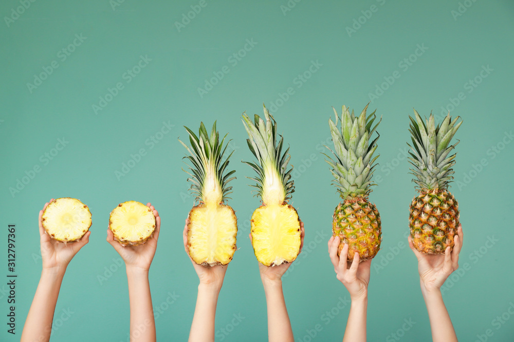 彩色背景上有多汁菠萝的手