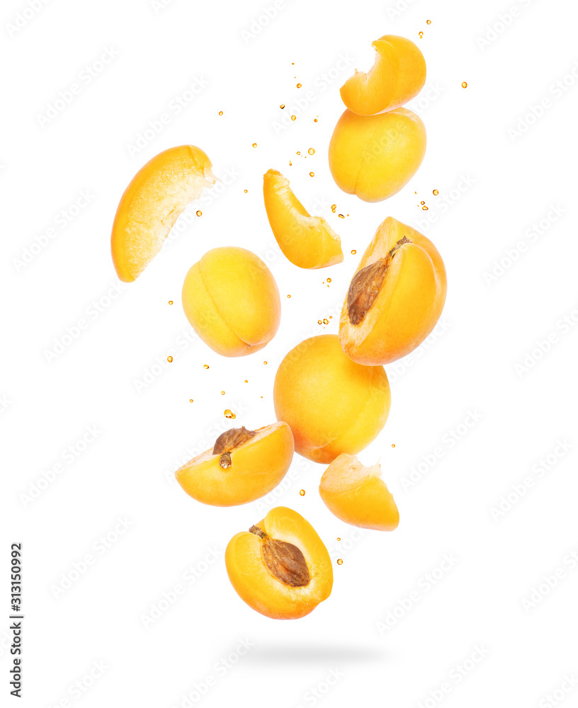 白色背景下，空气中新鲜的整颗和切片杏子