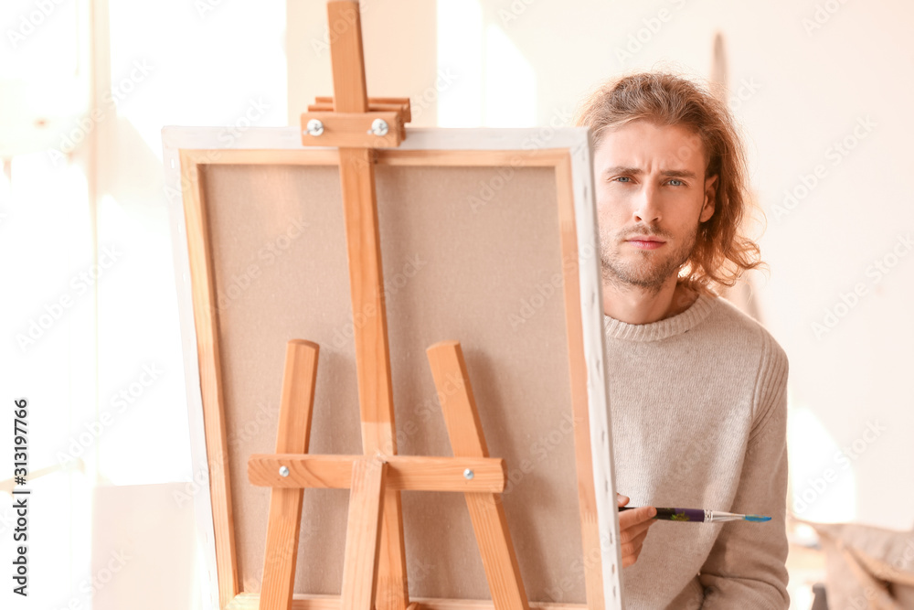 年轻男性艺术家在工作室绘画