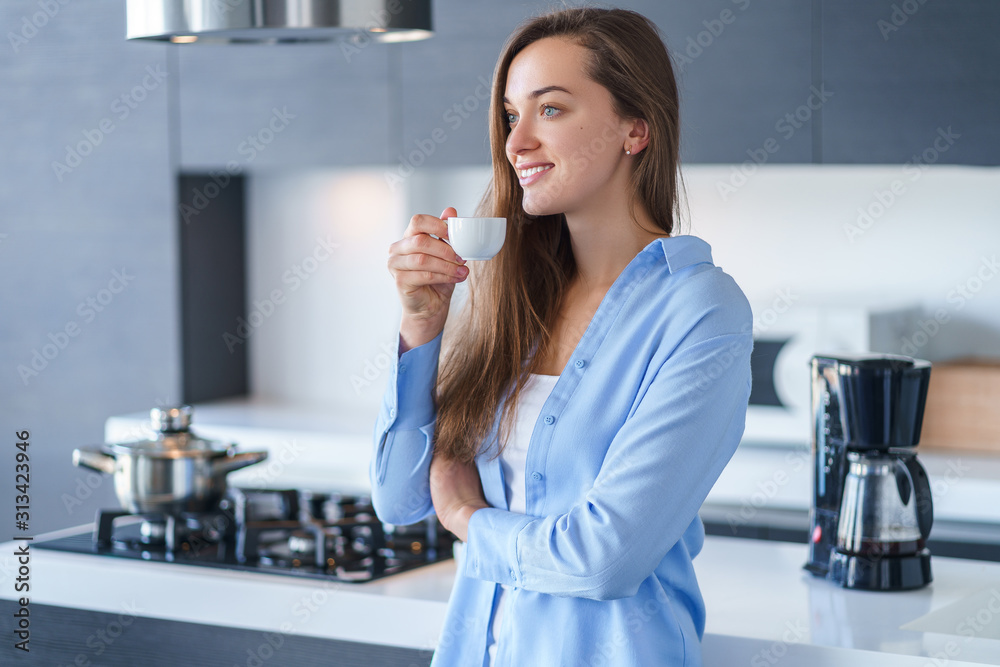 快乐迷人的微笑女性在冲泡咖啡后饮用并享受热的新鲜芳香咖啡