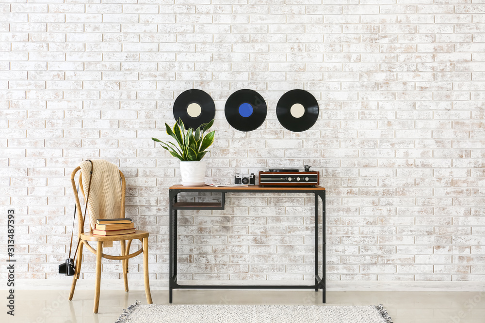 Record player with vinyl disc on table in interior of room