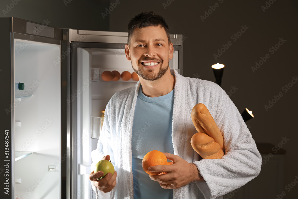 英俊男子晚上在冰箱里挑选食物