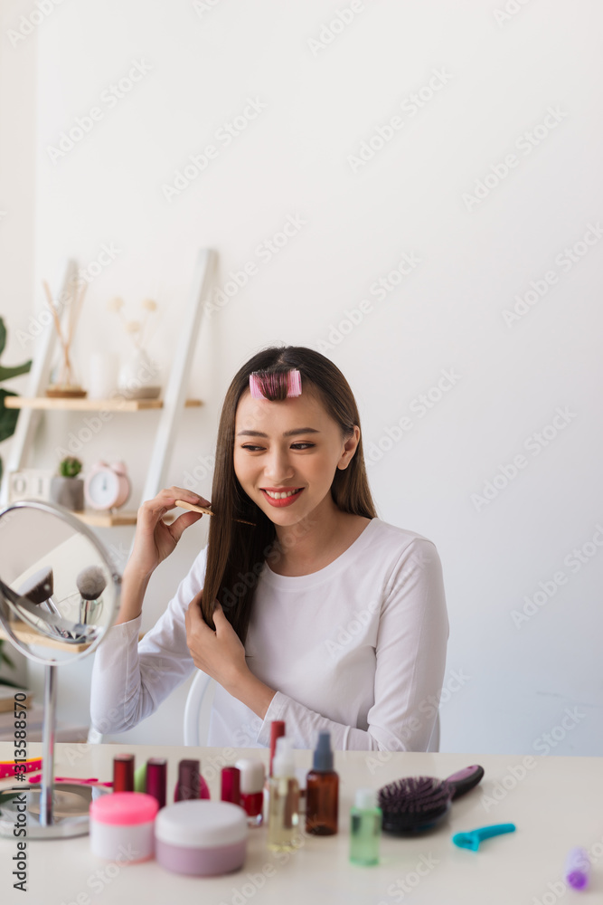 发型教程。一名亚洲女子在拍摄教程时梳头并愉快地微笑