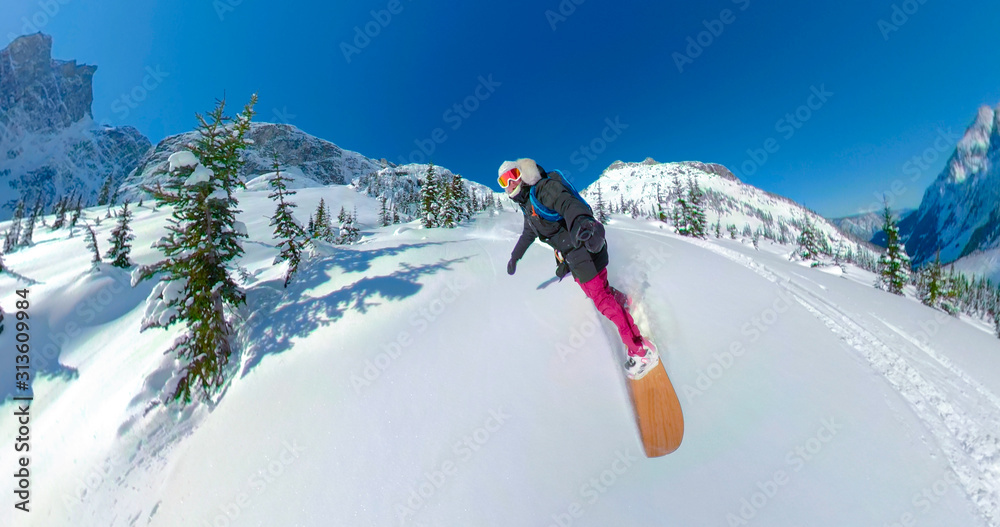 SELFIE：快乐的女单板滑雪运动员在风景如画的落基山脉滑雪