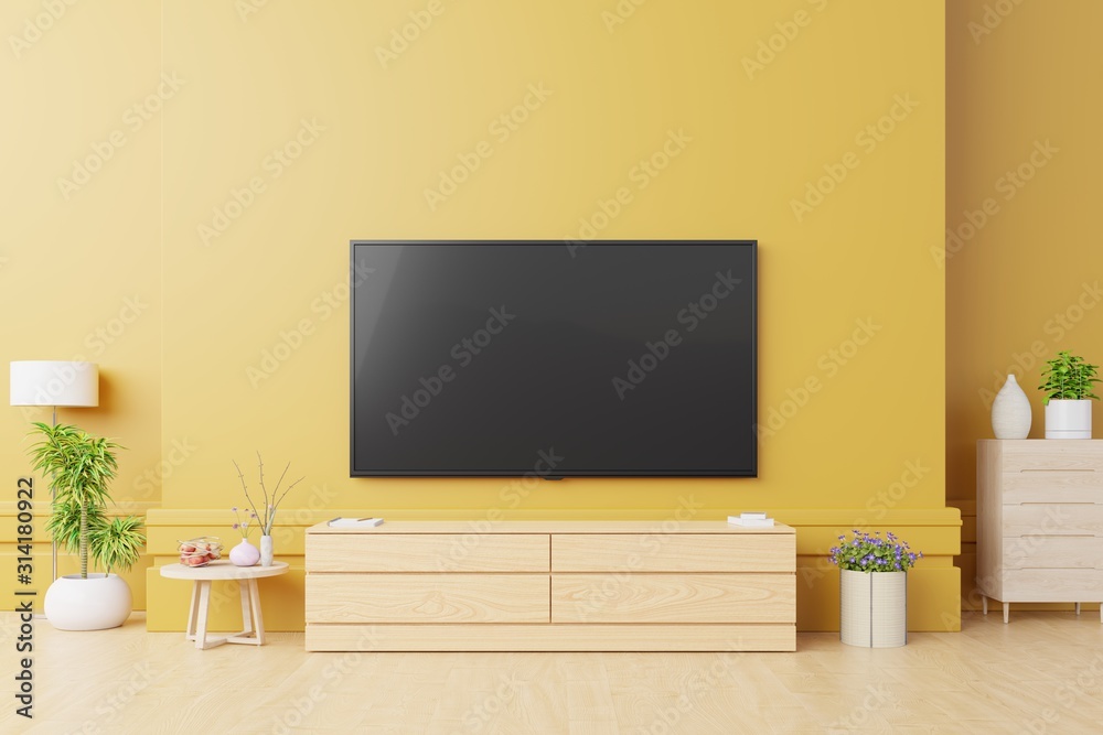 现代客厅的智能电视模型，黄色墙壁背景上有灯、桌子、花卉和植物。