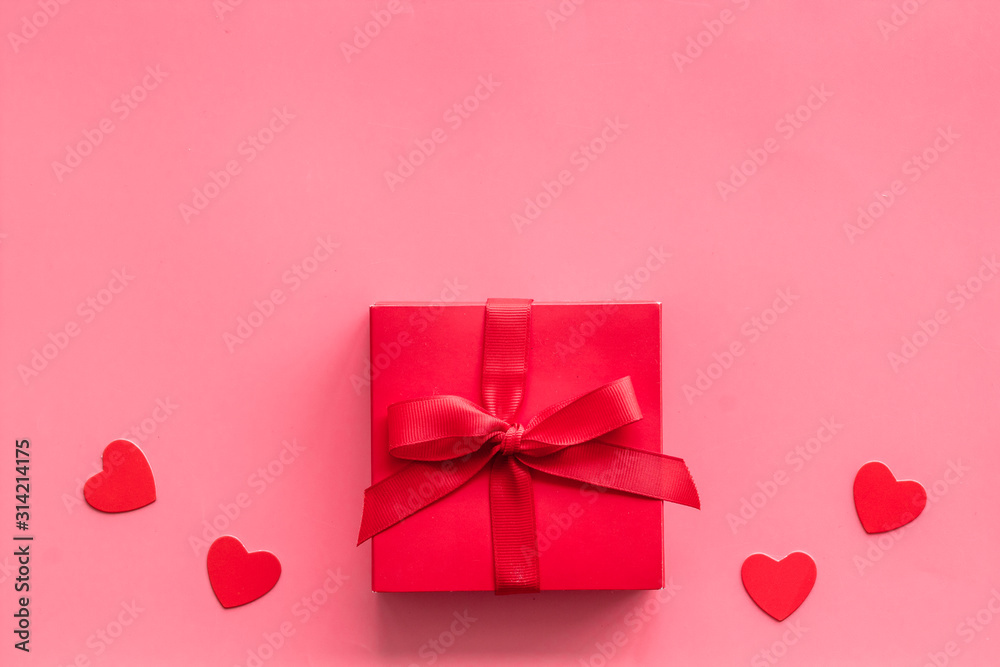 情人节送给爱人的礼物。粉色背景下靠近心形的红色礼物盒自上而下的警察