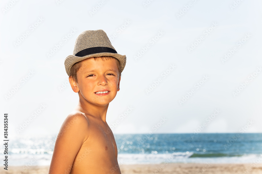 戴草帽的男孩在海上微笑的肖像