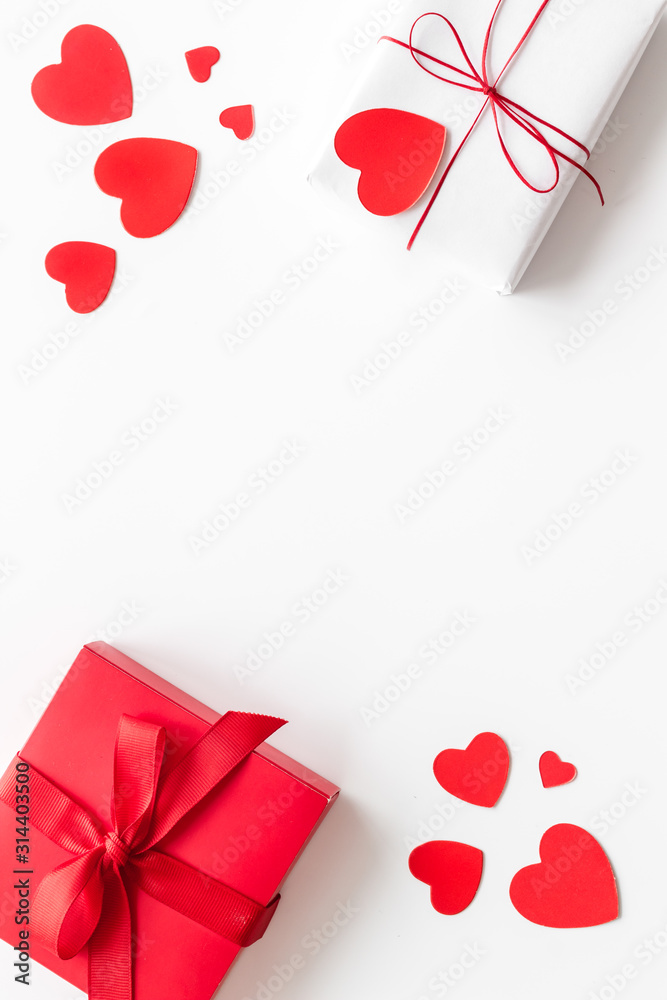 Present to a lover on Valentines Day. Gift boxes near paper hearts on white background top-down fra