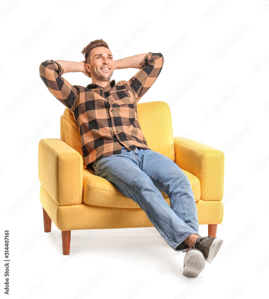 Handsome man sitting in armchair on white background