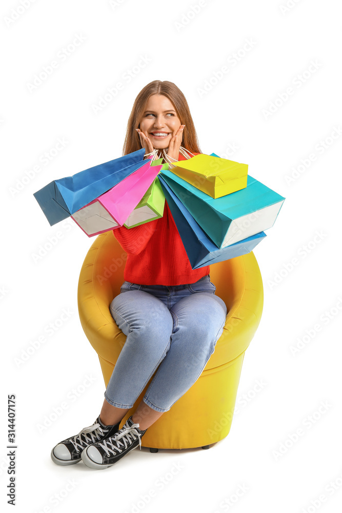 漂亮女人拿着购物袋坐在白底扶手椅上