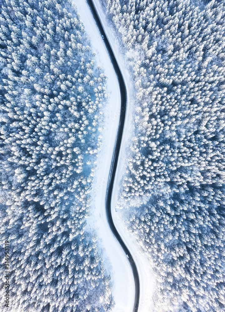 空中的自然冬季景观。冬季道路和森林的鸟瞰图。森林und