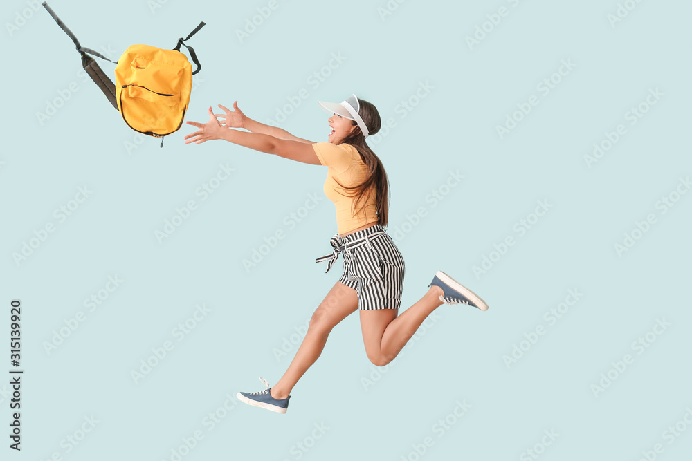 彩色背景背包跳跃的女人