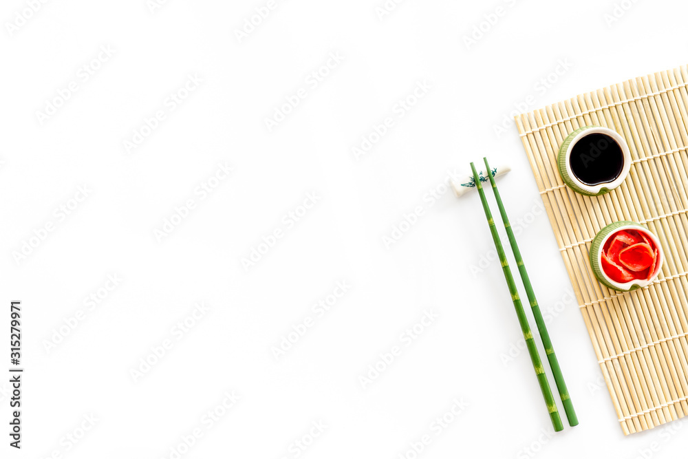 吃寿司的桌子。筷子，小碗里放着生姜和炒菜，垫子放在白背上