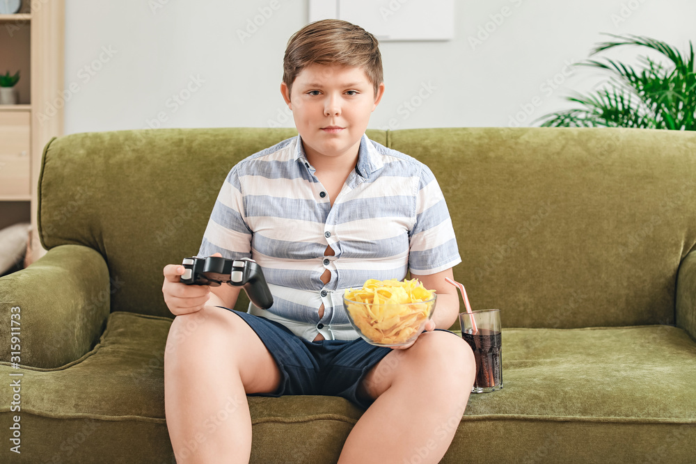 超重男孩带着芯片在家玩电子游戏