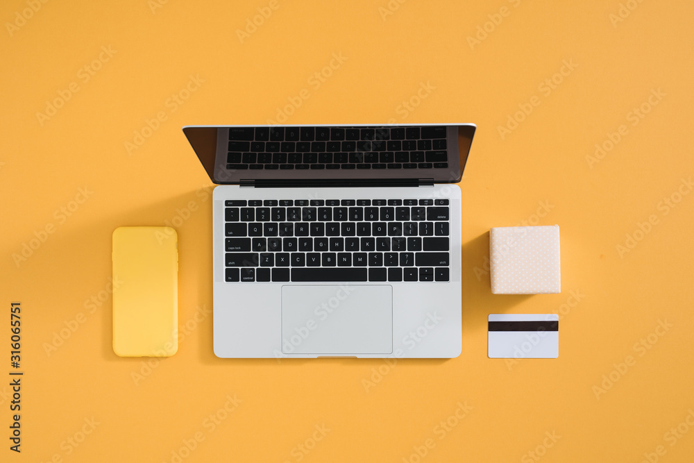 带手机的笔记本电脑和带彩色支付卡的礼盒。网上购物的概念