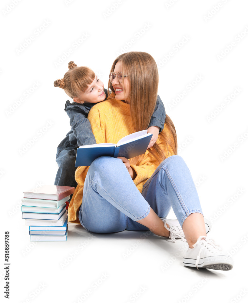 美丽的年轻女子和她的小女儿在白底看书