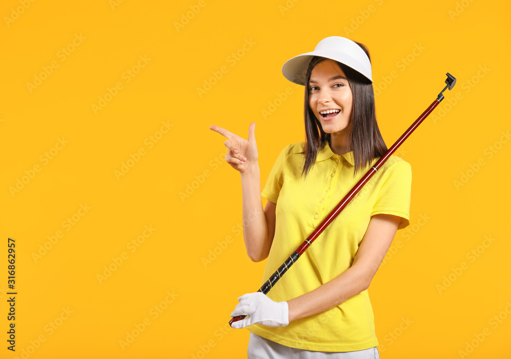 漂亮的女高尔夫球手指着彩色背景上的东西