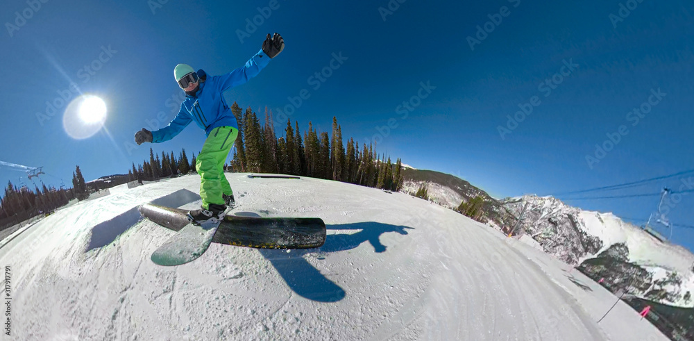 一个滑雪板运动员在雪地公园沿着栏杆滑行的精彩动作镜头