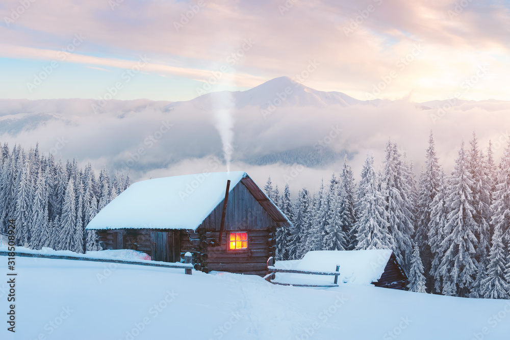 雪山木屋的奇妙冬季景观。烟雾从斯诺的烟囱里冒出来