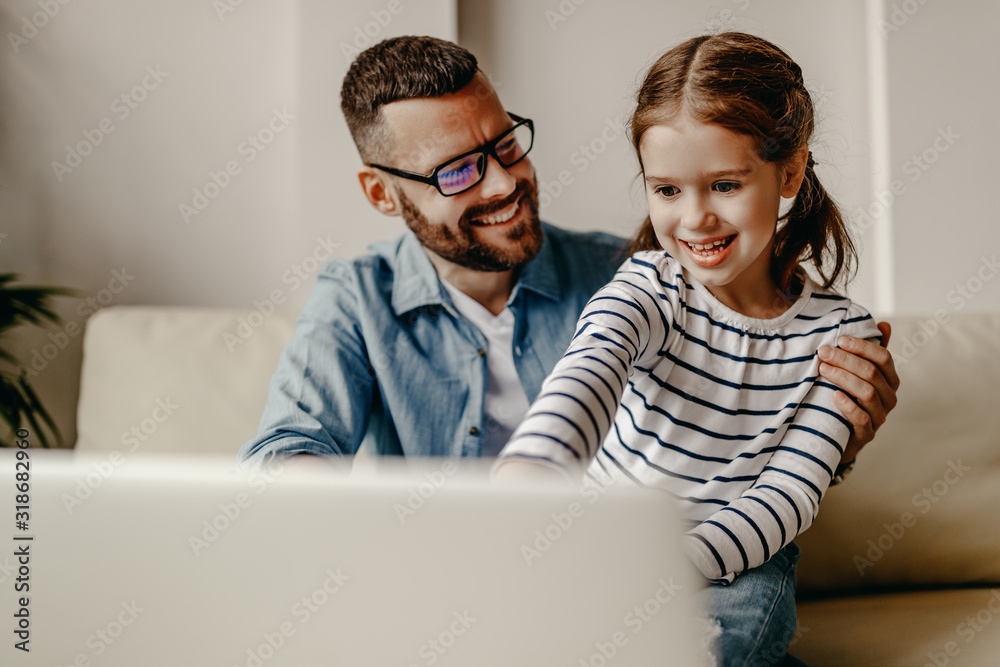 一个快乐的家庭，一个在电脑前工作的商人父亲和他的孩子女儿在家里。