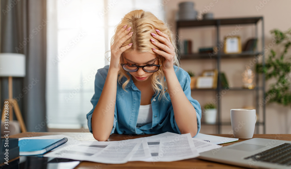 不快乐、疲惫的年轻商业女性，在家办公，在电脑上工作，压力很大。