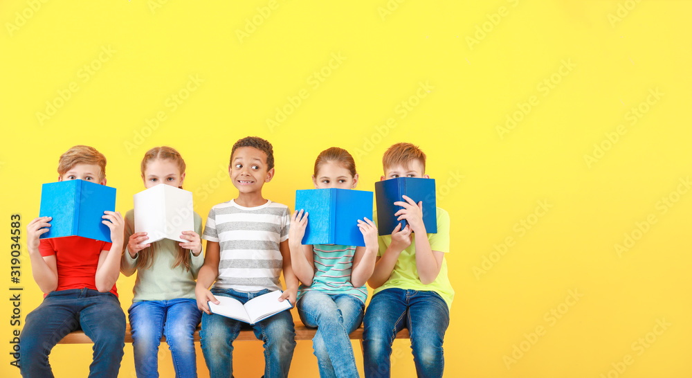 Cute little children with books on color background