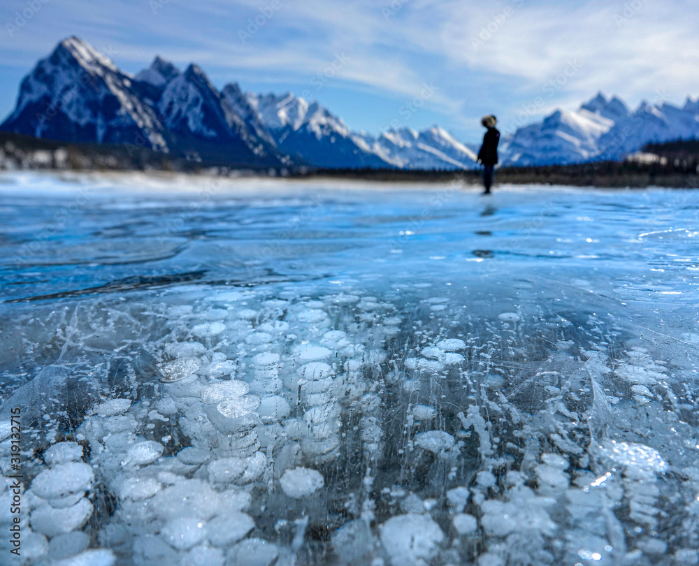 特写：一个无法辨认的人站在结冰的充满泡沫的亚伯拉罕湖上