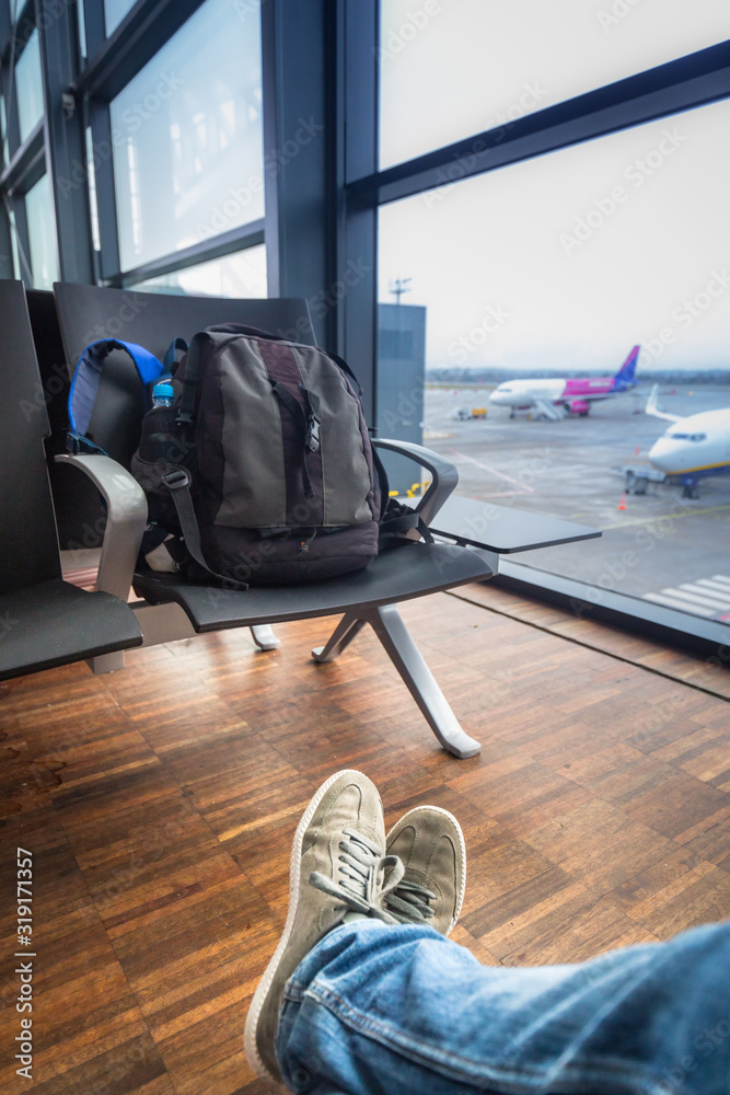 男子背着背包在机场等飞机