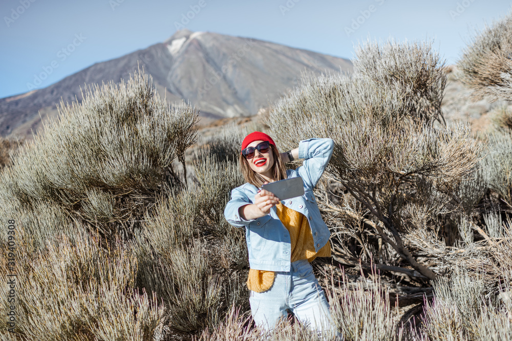 年轻女子在火山谷旅行时通过电话拍照或视频记录。生活方式tr