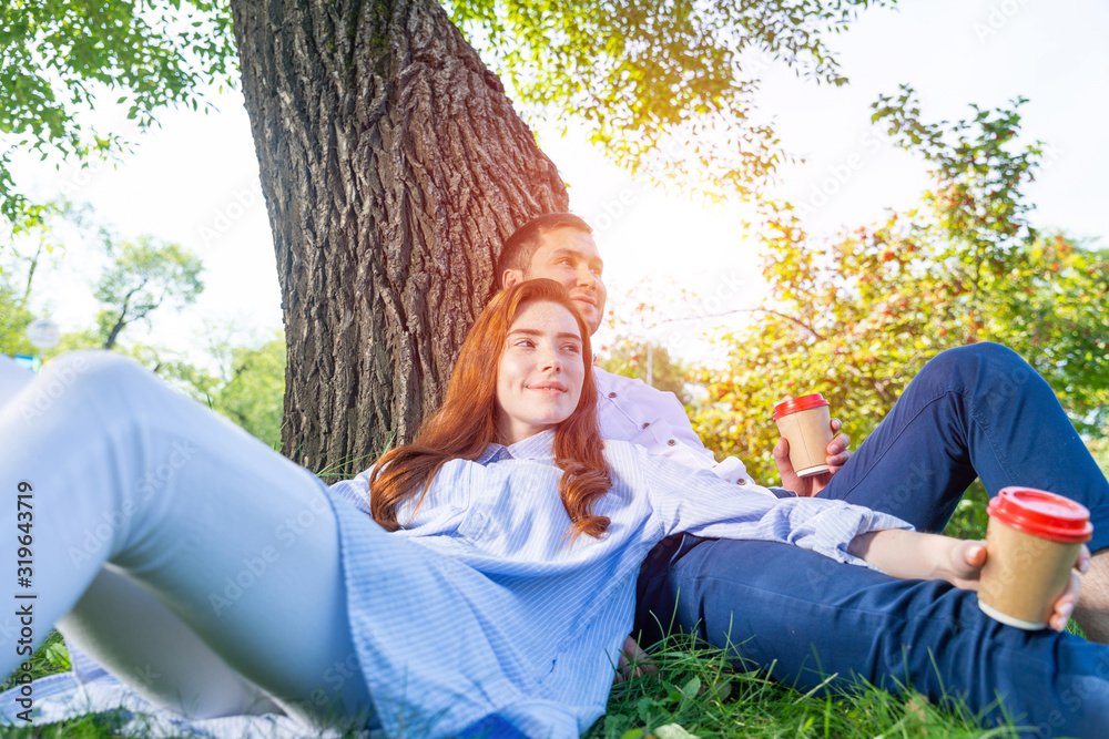 年轻夫妇在树下喝咖啡放松