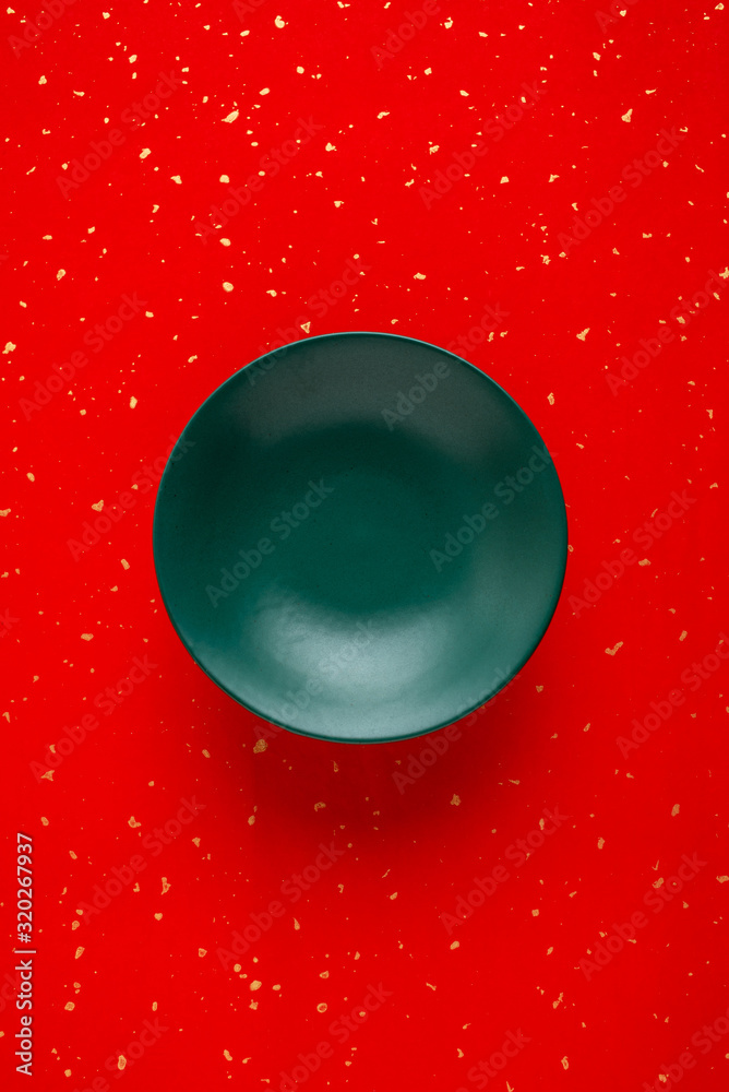 A dark green ceramic tall refreshment plate on a red background